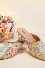 Stepellas white ethnic mules featuring colorful geometric embroidery, foil mirror work, and clear block heels.