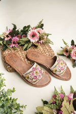 Stepellas white flat sandals featuring pink beaded floral handwork and a comfortable brown cushioned sole.
