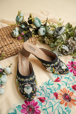 Stepellas black heeled mules featuring colorful traditional embroidery and closed-toe style.