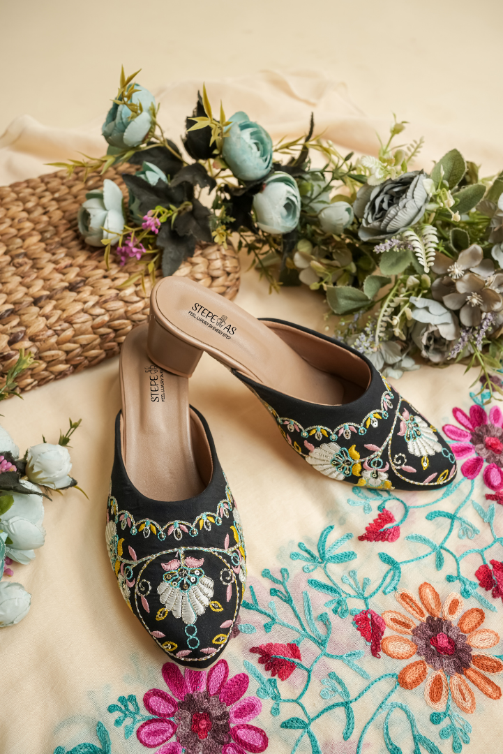 Stepellas black heeled mules featuring colorful traditional embroidery and closed-toe style.