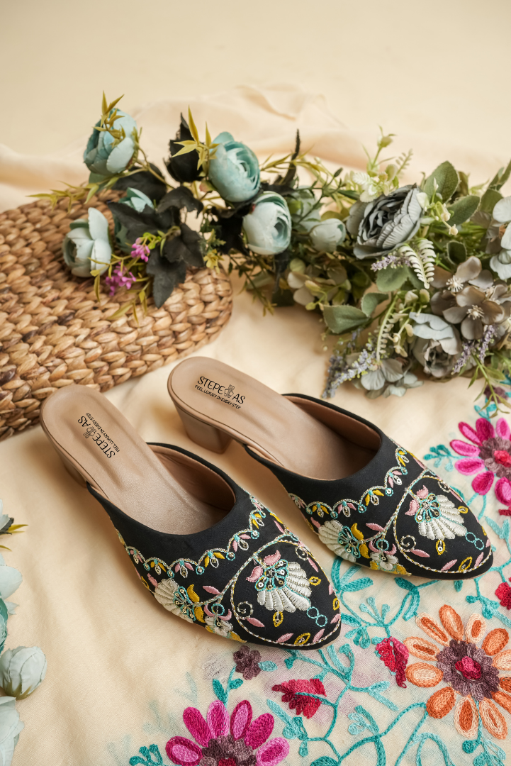 Black Stepellas flat mules with grey and tan floral embroidery and silver stud work.