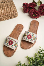 Stepellas black handmade flat chappals featuring vibrant pink, yellow, and peach floral hand-embroidery.