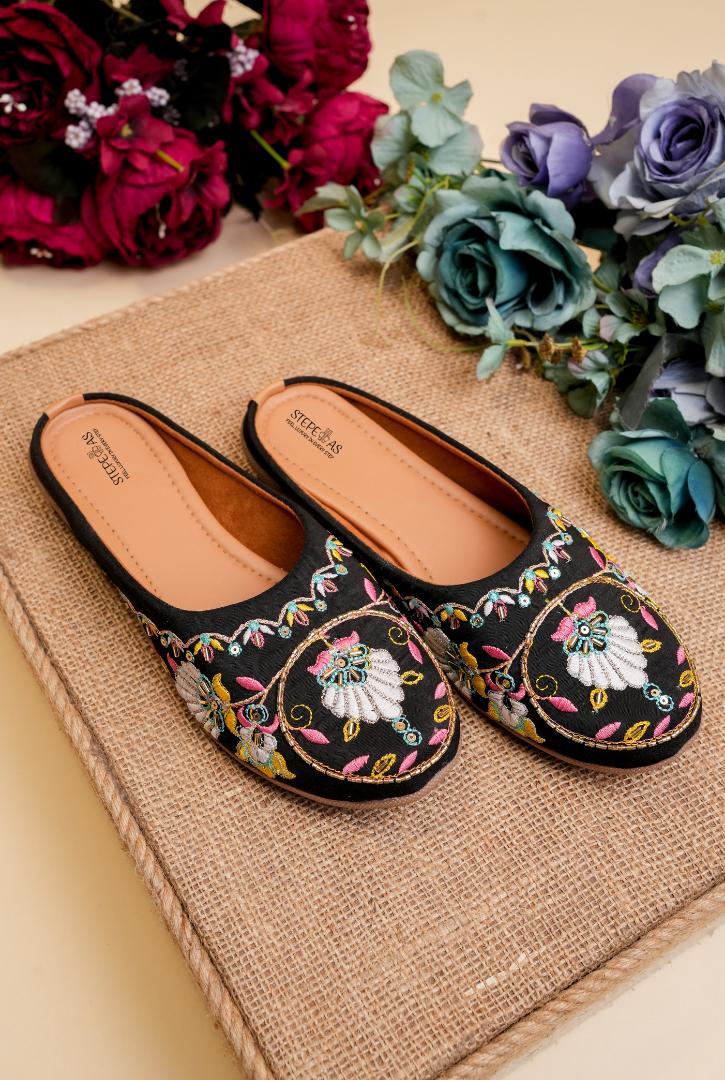 Designer Stepellas black heeled mules featuring the signature round floral embroidery and a stable block heel.