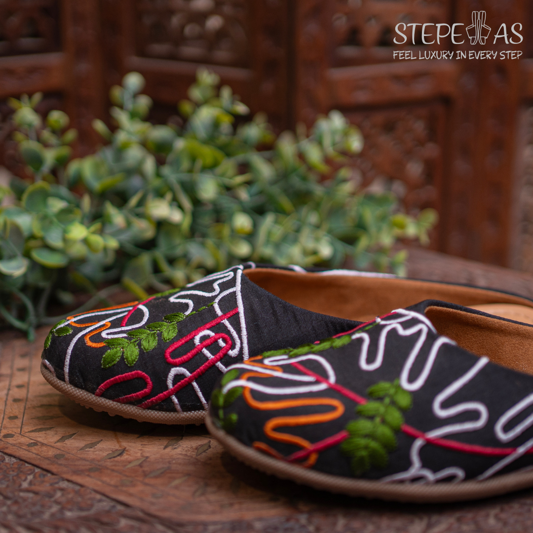 Traditional Stepellas black mojdis with intricate round Siroski stone work and fan-shaped embroidery.