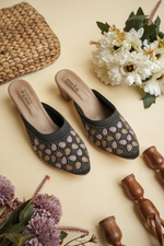 Black Stepellas heeled mules featuring rose-gold leaf-shaped stud patterns and a comfortable block heel.
