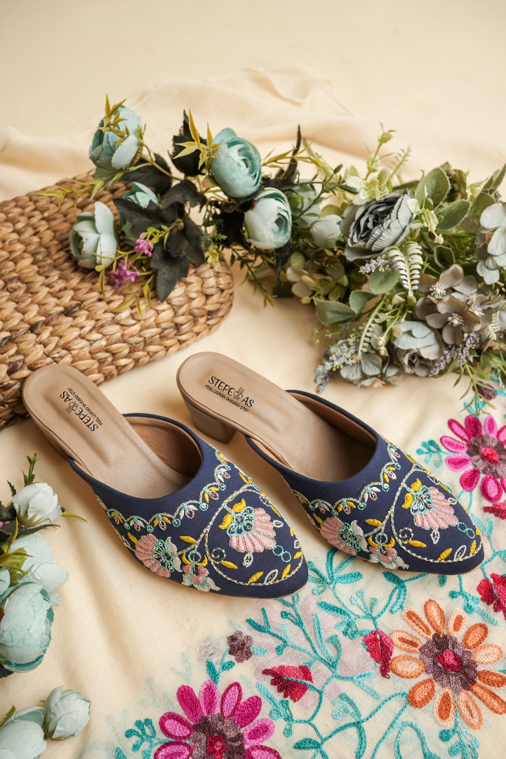 Detailed close-up of the intricate pink floral and golden vine embroidery on Stepellas royal blue heels.