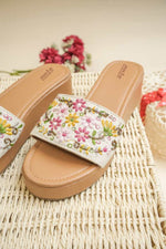 Close-up of the detailed multi-color floral hand-embroidery on Stepellas brown ethnic footwear.