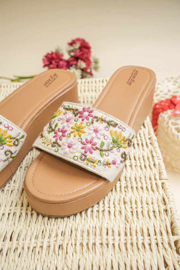 Close-up of the detailed multi-color floral hand-embroidery on Stepellas brown ethnic footwear.