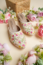 Elegant Stepellas cream embroidery heels displayed with pink roses and wicker decor for a bridal aesthetic.