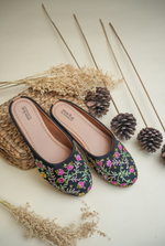 Top view of Stepellas branded black embroidered juttis highlighting the soft cushioned tan insole.