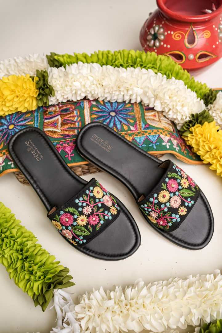 Branded Stepellas black flat sandals highlighting the soft, padded cushioned footbed for all-day comfort.