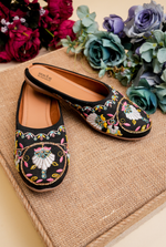 Top view of Stepellas branded black round embroidery juttis highlighting the soft padded tan insole for comfort.