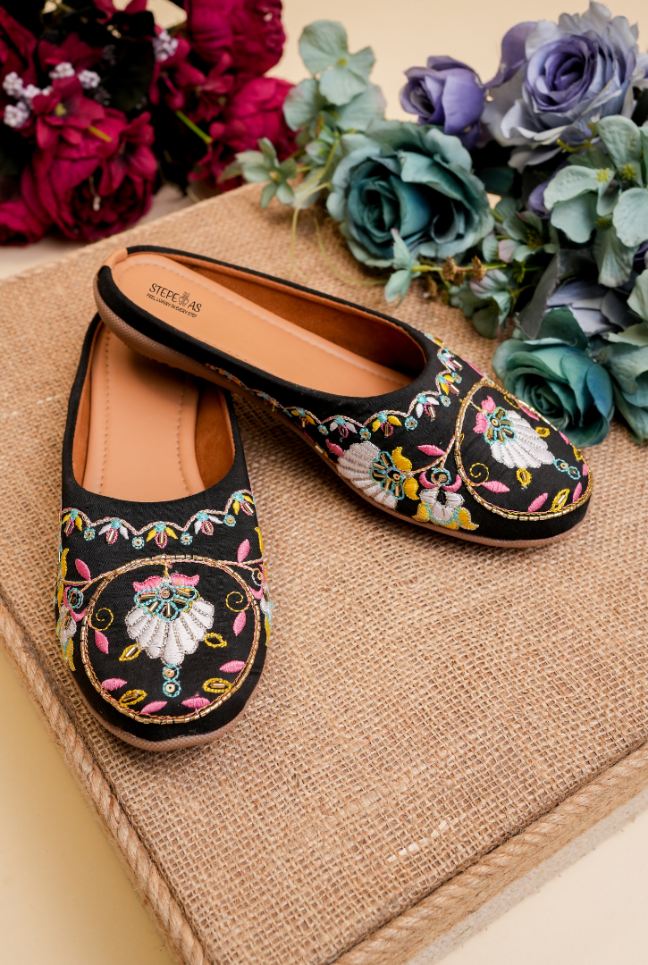 Top view of Stepellas branded black round embroidery juttis highlighting the soft padded tan insole for comfort.