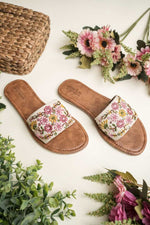 Top view of Stepellas white embroidered sandals highlighting the branded brown padded footbed for comfort.