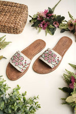 Branded Stepellas white flat sandals highlighting the soft, padded tan leather-style footbed for comfort.
