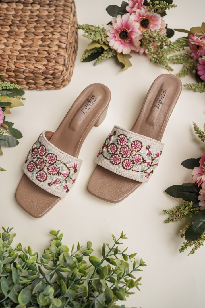 Top view of Stepellas branded white heels highlighting the comfortable cushioned footbed and red floral design.