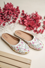 Top view of Stepellas branded white floral juttis highlighting the soft cushioned tan insole for comfort.