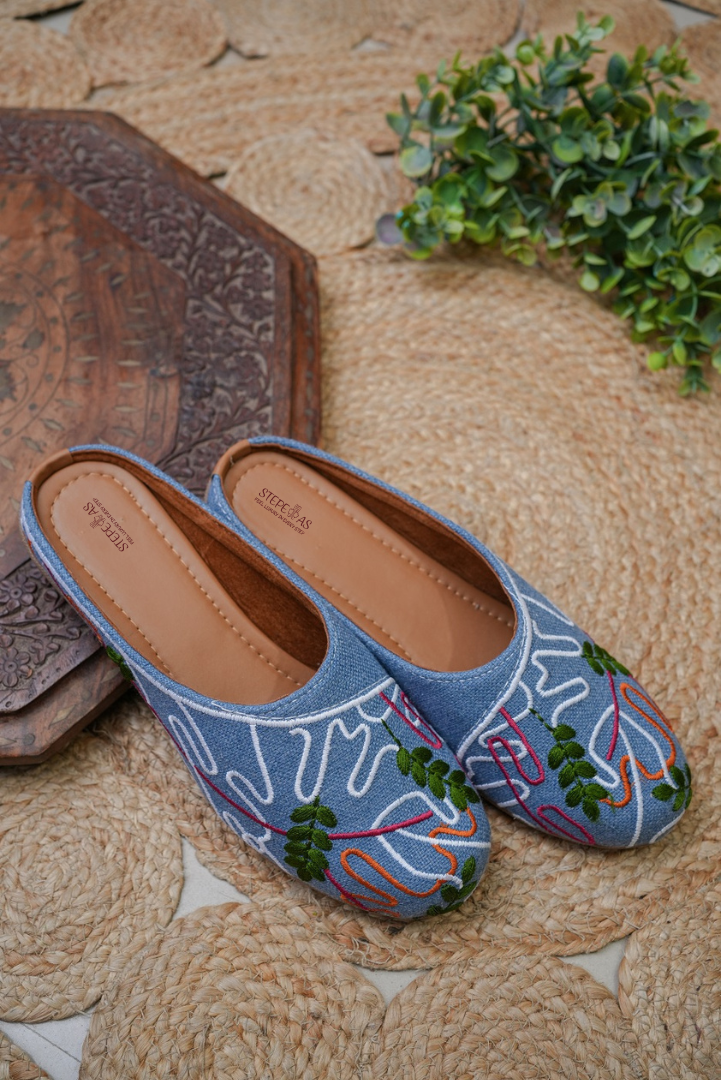 Stepellas black denim-style juttis featuring modern white line-art and green leaf hand embroidery.