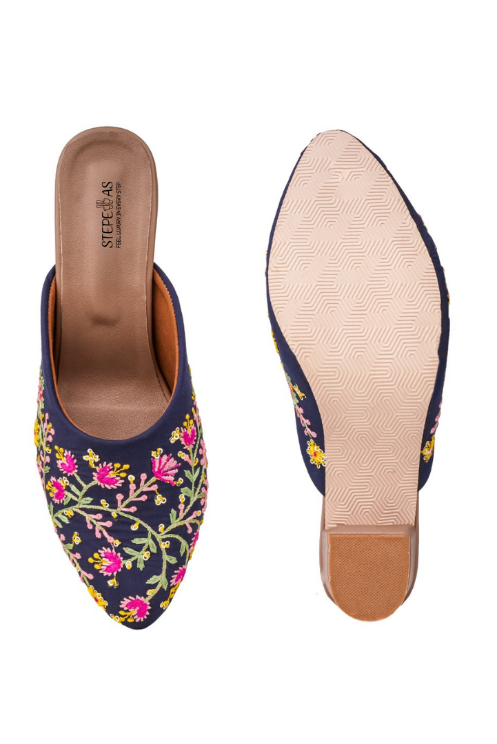 Elegant Stepellas blue flower embroidery heels displayed with pink flowers on a woven base for a festive look.