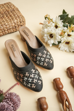 Side profile of Stepellas black ethnic heeled mules showing the stable block heel and square stone work.