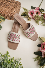 Side view of Stepellas white ethnic sandals showing the vibrant red flower threadwork and transparent block heel.