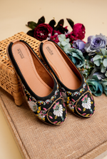 Detailed close-up of the intricate round stone work and multi-colored embroidery on Stepellas black ethnic footwear.