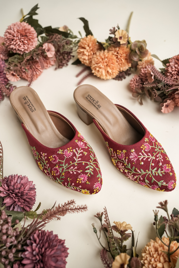 Intricate hand-embroidered floral patterns on Stepellas maroon ethnic footwear with comfortable block heels.