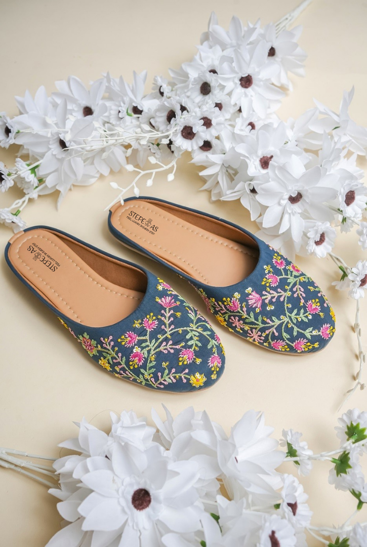Stepellas navy blue juttis featuring vibrant pink and yellow floral vine (vel) embroidery.