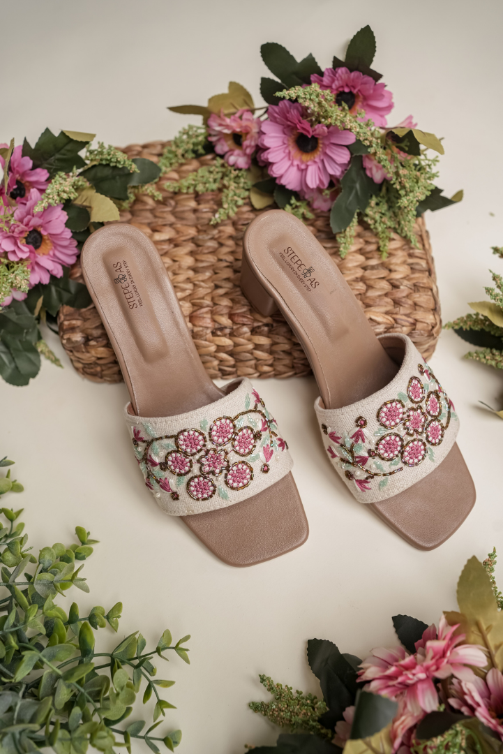 Stepellas white square-toe sandals featuring a large red floral embroidery and clear block heels.