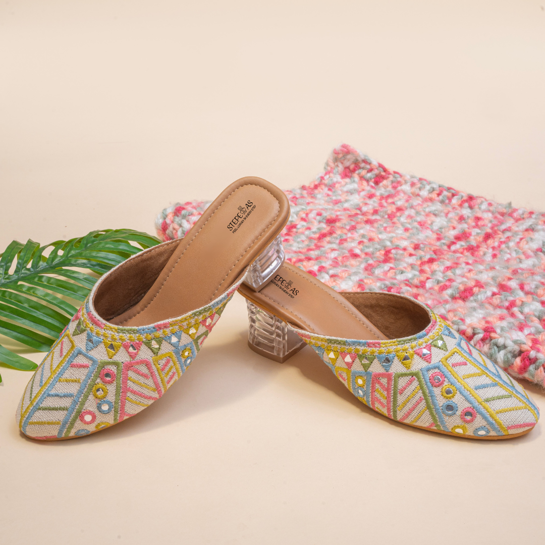 Elegant Stepellas white foil mirror work heels styled with festive floral decor for wedding and party wear.